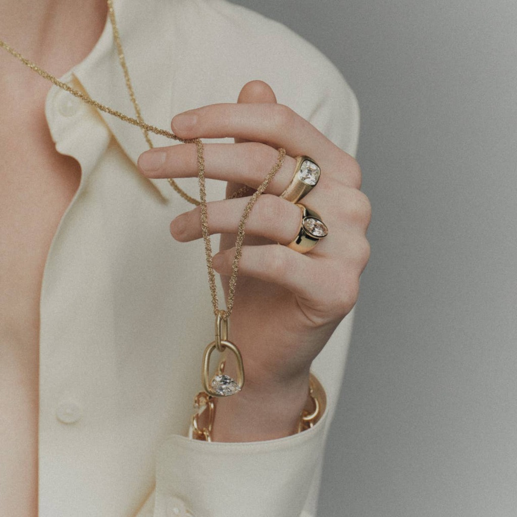 A model holding a Jade Ruzzo necklace and wearing signature sculptural rings
